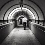 This photo is shot down a tunnel which leads to the man down the tunnel, creating good composition.