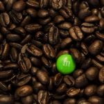 The contrast between the lime green M&M and the dark brown coffee beans really pops the M&M out creating good composition.